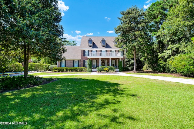 view of front of home featuring a balcony and a front yard