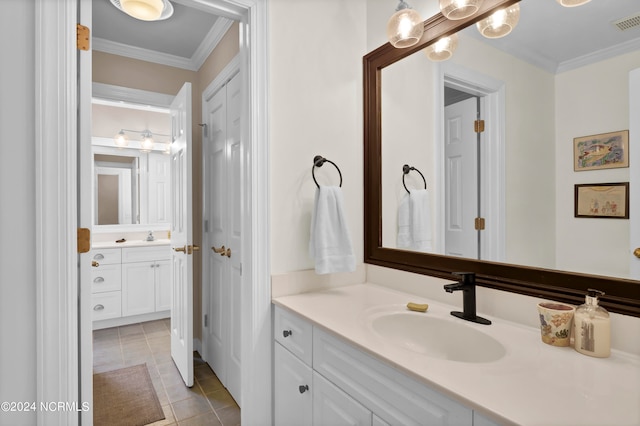 bathroom with tile patterned flooring, ornamental molding, and vanity