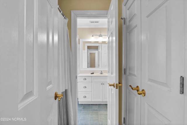 bathroom with crown molding, vanity, and tile patterned floors