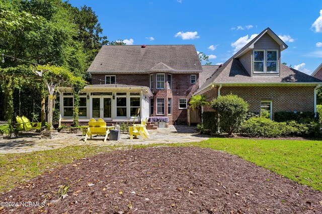 rear view of property with a sunroom and a patio