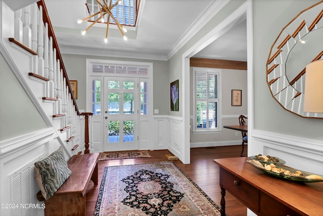 foyer entrance with a wealth of natural light, crown molding, an inviting chandelier, and dark hardwood / wood-style flooring