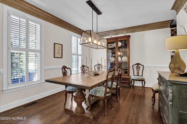 dining area featuring dark wood-type flooring and ornamental molding