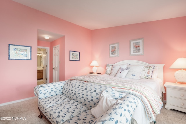 bedroom with light colored carpet, ensuite bath, and a closet