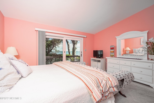 carpeted bedroom with vaulted ceiling and access to outside