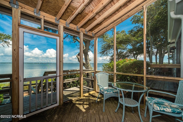 unfurnished sunroom featuring a water view and lofted ceiling