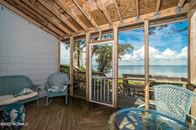 sunroom featuring lofted ceiling and a water view