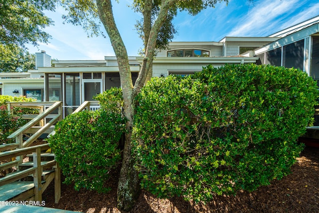 rear view of property featuring a sunroom