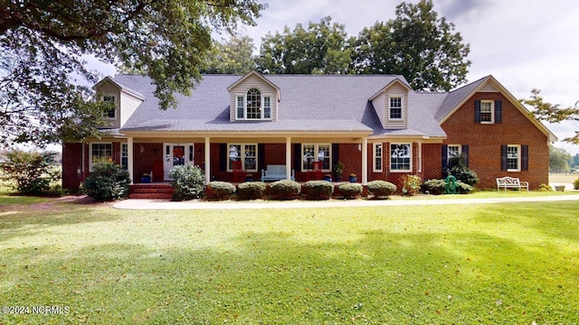 cape cod house featuring a front yard and a porch