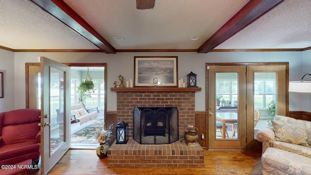 living room with a textured ceiling, beam ceiling, and hardwood / wood-style flooring