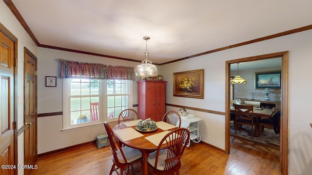 dining room featuring crown molding and light hardwood / wood-style floors