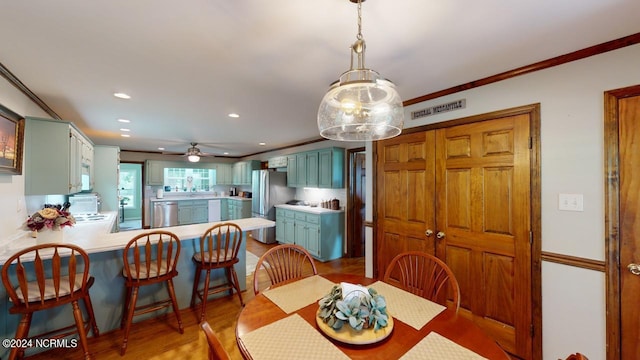 dining space with ceiling fan with notable chandelier, ornamental molding, and dark hardwood / wood-style floors