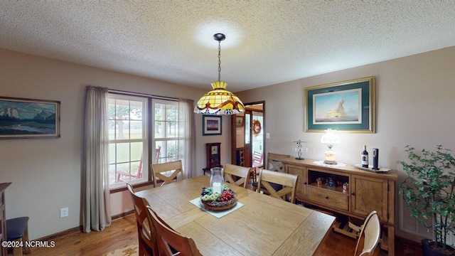 dining room with a textured ceiling and light hardwood / wood-style flooring