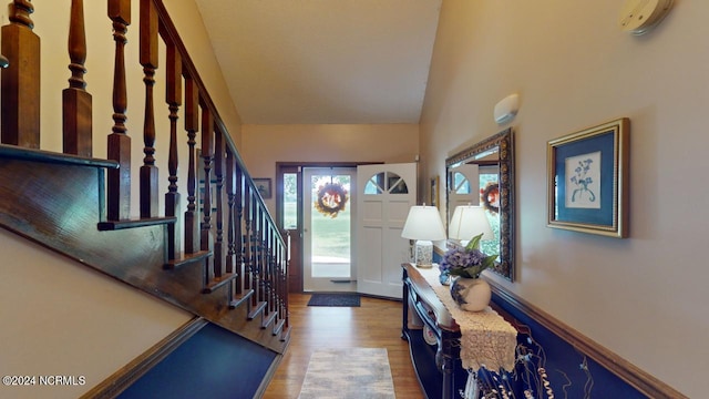 foyer with vaulted ceiling and light hardwood / wood-style flooring