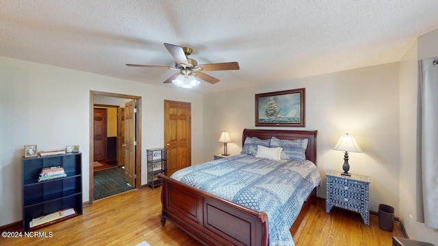 bedroom with wood-type flooring, ceiling fan, a textured ceiling, and connected bathroom