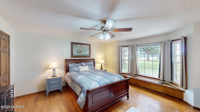 bedroom featuring ceiling fan, a textured ceiling, and light hardwood / wood-style floors