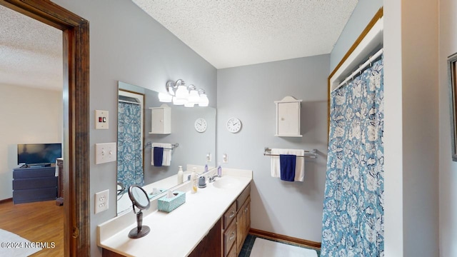 bathroom featuring a textured ceiling, vanity, and hardwood / wood-style flooring