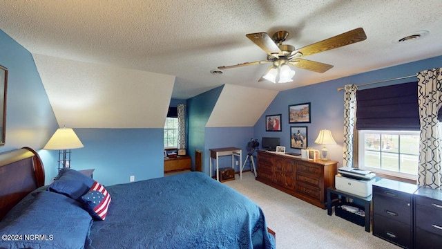 bedroom featuring a textured ceiling, vaulted ceiling, ceiling fan, and light colored carpet