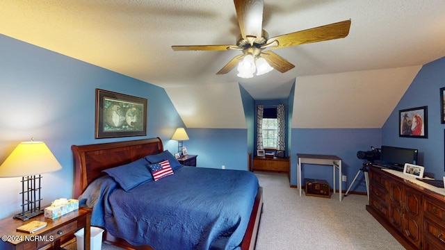 bedroom with a textured ceiling, vaulted ceiling, ceiling fan, and light colored carpet