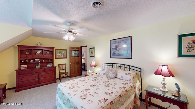 bedroom with vaulted ceiling, ceiling fan, light colored carpet, and a textured ceiling