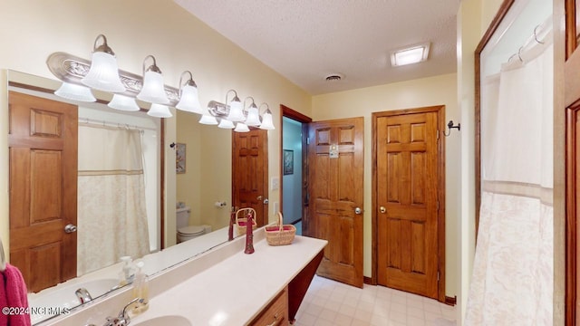 bathroom featuring vanity, toilet, and a textured ceiling