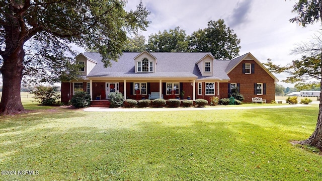 new england style home with a front yard and a porch