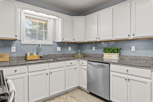 kitchen with stainless steel dishwasher, decorative backsplash, white cabinets, and a sink