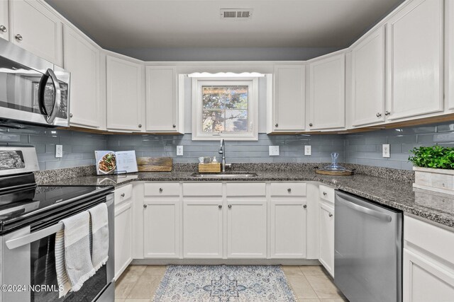 kitchen with visible vents, a sink, white cabinetry, appliances with stainless steel finishes, and decorative backsplash