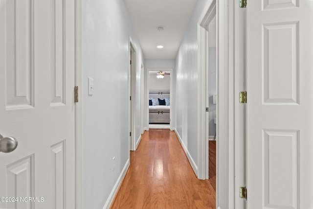 hallway with light wood finished floors and baseboards