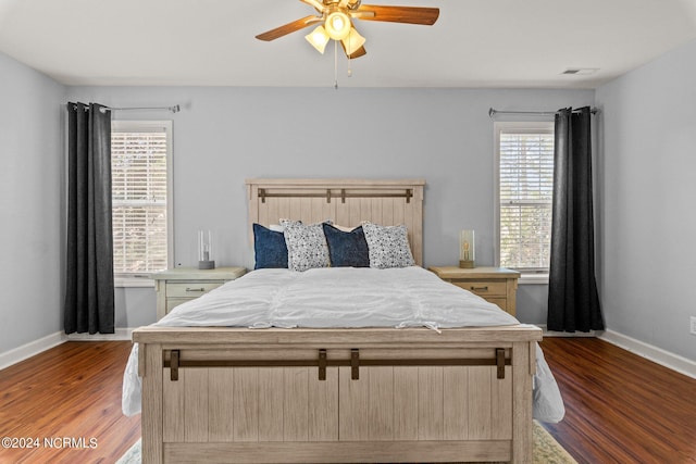 bedroom with visible vents, a ceiling fan, baseboards, and wood finished floors