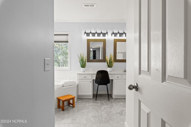 full bathroom featuring visible vents, a garden tub, and vanity