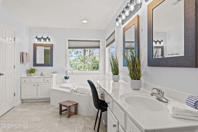 full bathroom featuring a sink, a garden tub, and two vanities