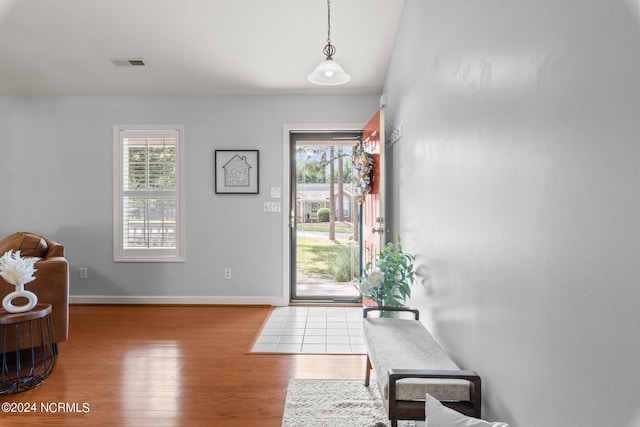 foyer featuring visible vents, baseboards, and wood finished floors