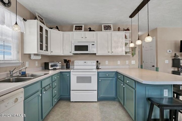 kitchen with white cabinets, kitchen peninsula, sink, pendant lighting, and white appliances