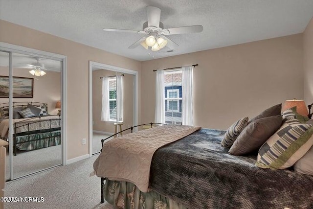 carpeted bedroom featuring ceiling fan and a textured ceiling