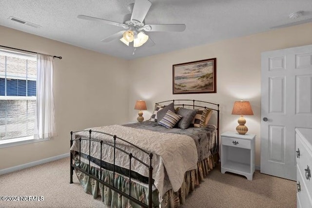 carpeted bedroom featuring a textured ceiling and ceiling fan