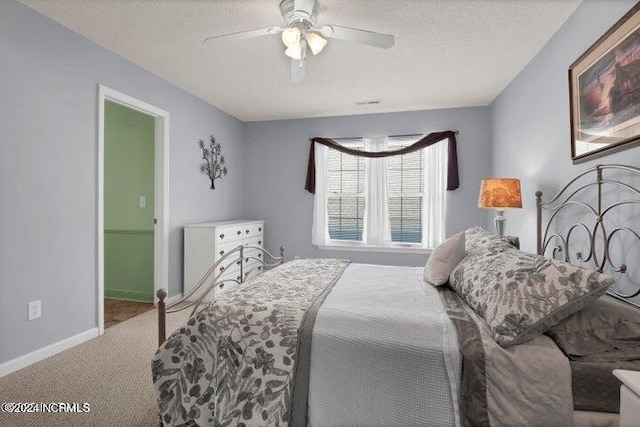 bedroom with a textured ceiling, carpet flooring, and ceiling fan