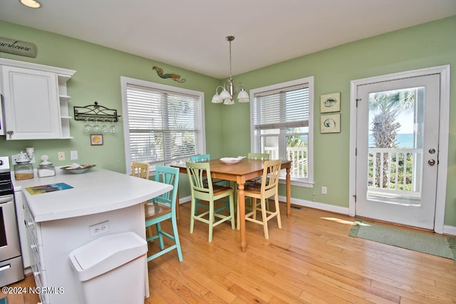 dining area with a notable chandelier and light hardwood / wood-style flooring