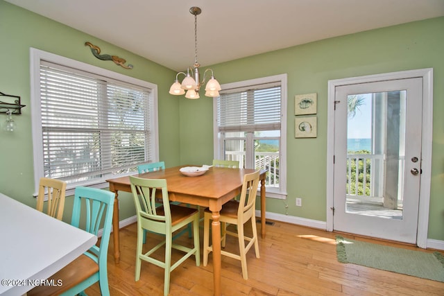 dining area with a wealth of natural light, a chandelier, and light hardwood / wood-style floors