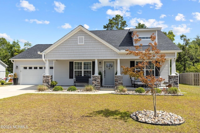 craftsman house featuring a porch, a garage, and a front lawn