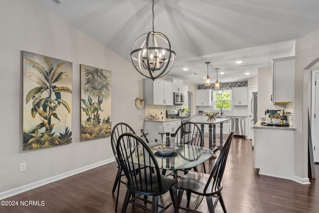 dining space with vaulted ceiling, an inviting chandelier, dark wood-type flooring, and sink