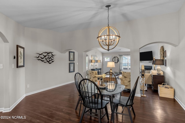 dining room with dark hardwood / wood-style flooring and a chandelier