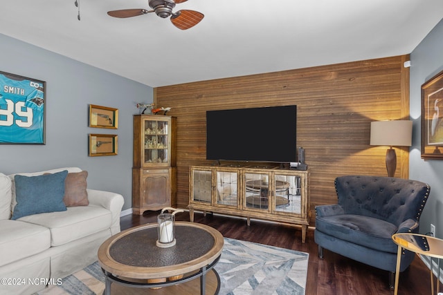 living room featuring wood walls, dark hardwood / wood-style flooring, and ceiling fan