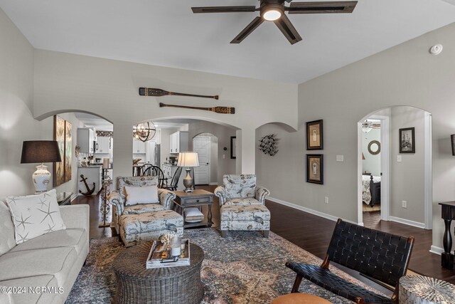 living room featuring dark hardwood / wood-style flooring and ceiling fan with notable chandelier