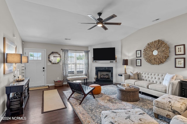 living room with a fireplace, dark hardwood / wood-style floors, ceiling fan, and lofted ceiling