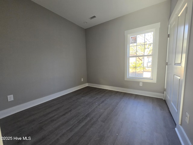 empty room with dark hardwood / wood-style flooring