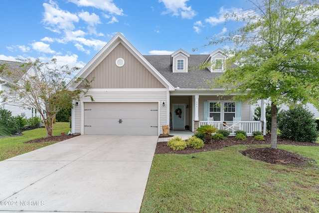 view of front of house with a garage, a front lawn, and a porch