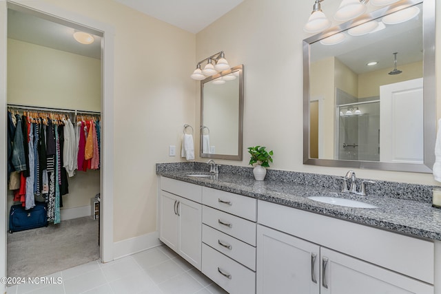 bathroom featuring tile patterned flooring, a shower with door, and vanity