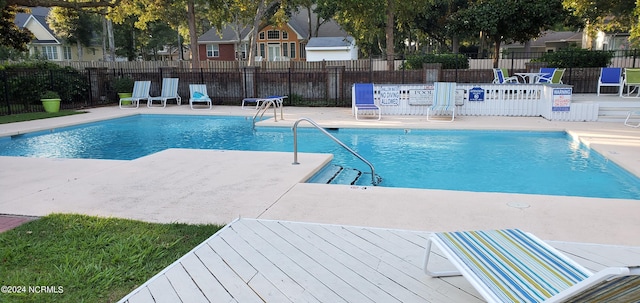 pool with a patio area and fence