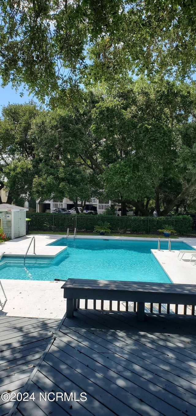 community pool with a deck and fence