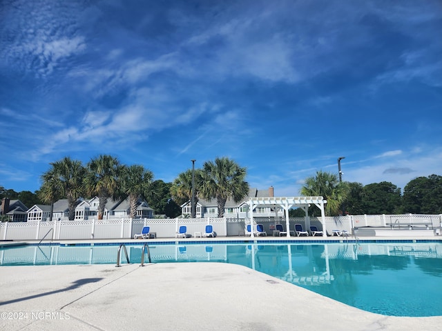 community pool with a patio area, fence, and a pergola